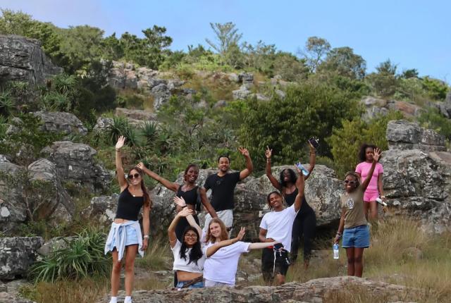 Students wave from a hillside in Cape Town