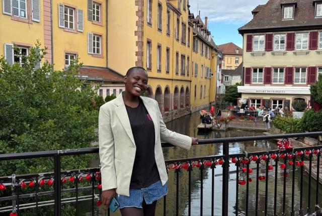 Victoria stands in front of yellow houses in Freiburg, Germany.