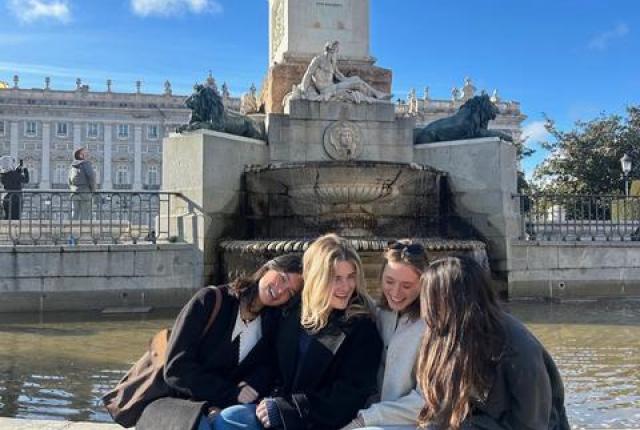 Friends soaking up the sun in Plaza de Oriente in Madrid