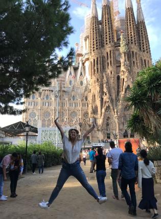 a student jumping for joy in from of Basílica de la Sagrada Família in Barcelona