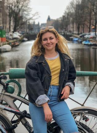 student posing in front of an Amsterdam canal