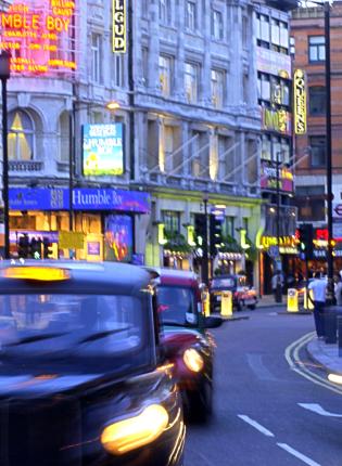 cars drive down a London street