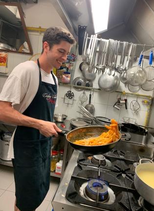 a student intern making pasta in a kitchen