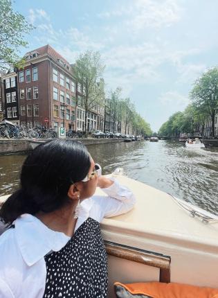 a student riding through the Amsterdam canals on a boat