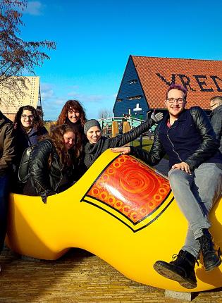 students pose for a photo in a giant clog in Amsterdam