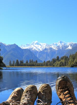 a photo of students hiking boots in front of New Zealand mountains