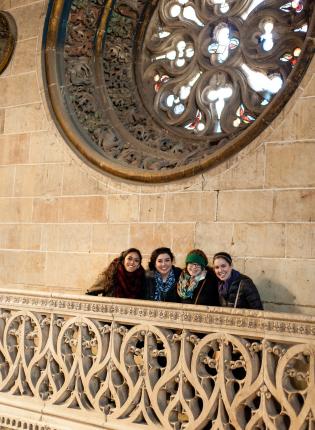 a group of girls standing by a stained glass window