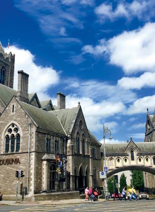 The large stone Dublin Catherdral with blue sky and white clouds in the background