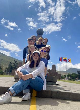 a group of students pose in front of Mitad del Mundo for a fun photo