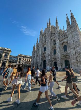 Group of students walking past the Duomo in Milan on a sunny morning