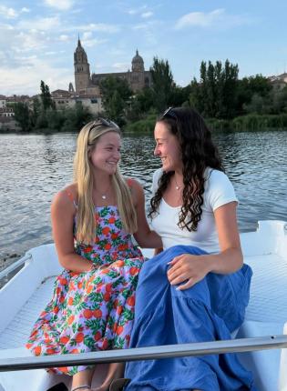 Two female students smile on the rowboats in Salamanca.
