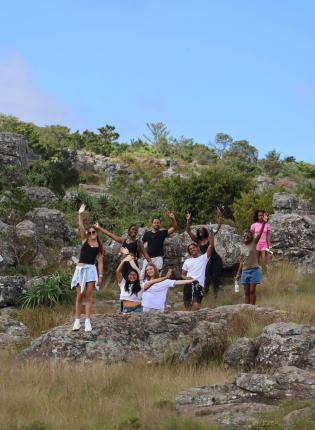 Students wave from a hillside in Cape Town