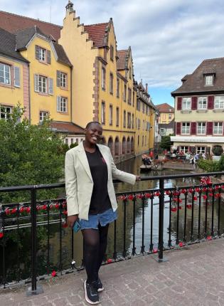 Victoria stands in front of yellow houses in Freiburg, Germany.