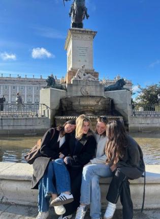 Friends soaking up the sun in Plaza de Oriente in Madrid