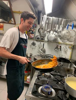 a student intern making pasta in a kitchen