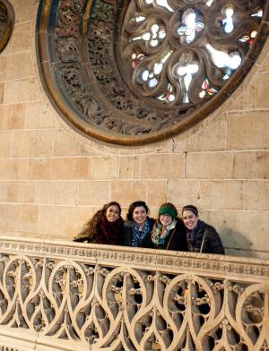 a group of girls standing by a stained glass window