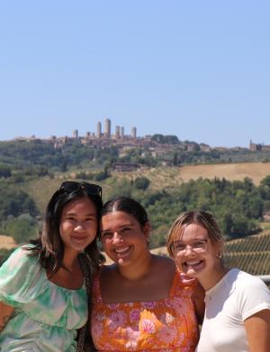 three students pose for a photo in front of Siena