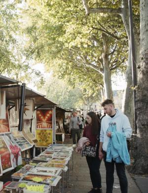 Students check out items at a street vendor in Paris, France.