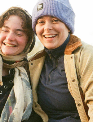 Two students sitting by the amstel in Amsterdam