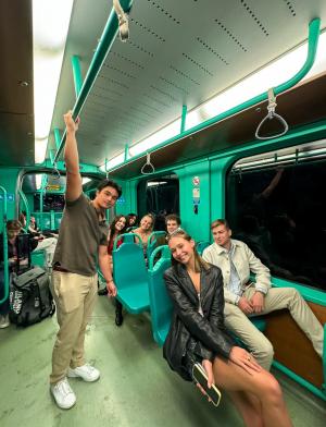 Several smiling students riding public transportation together