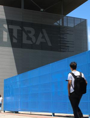 a student wearing a backpack walking toward an ITBA building
