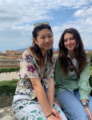 Two friends sitting on a ledge at an overlook of Florence