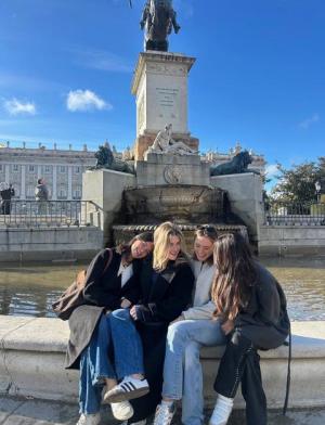 Friends soaking up the sun in Plaza de Oriente in Madrid