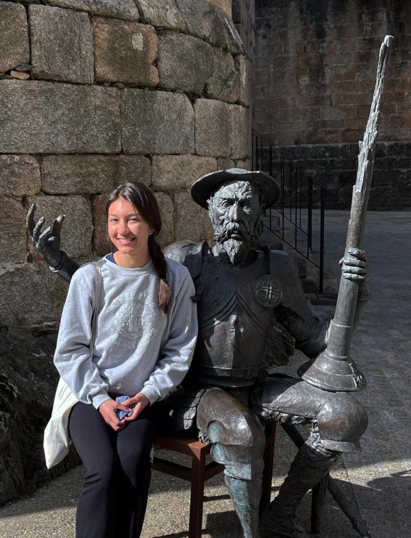 A student sits with a statue of the fictional hero from Don Quixote in Spain.