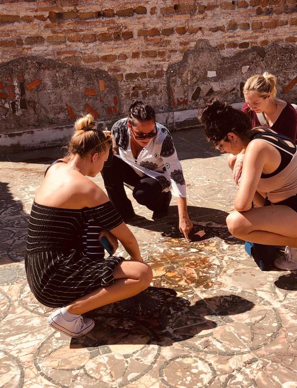 Students viewing mosaic floor tiles at Ostia Antica