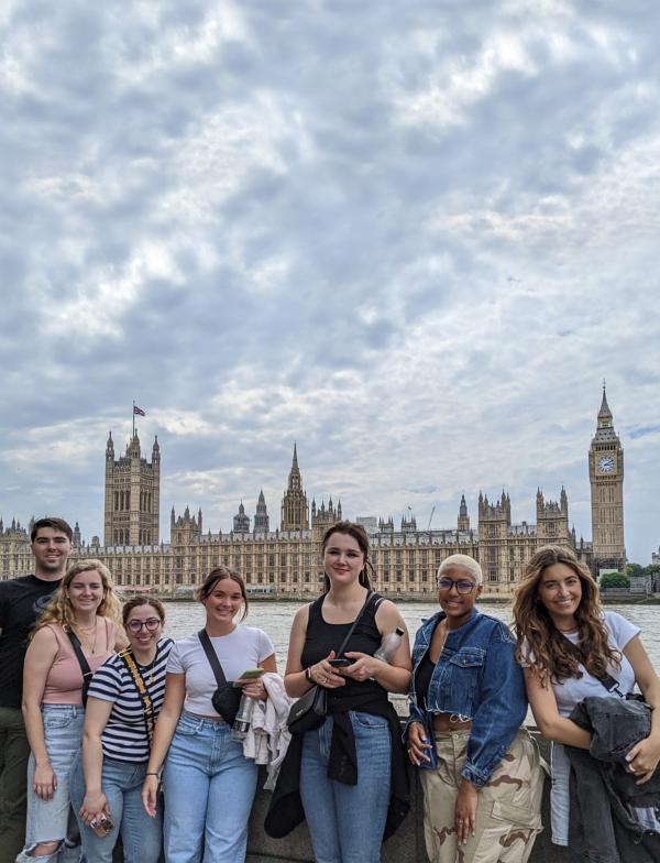 A group of students posing for a photo in front of British Parliament and the River Thames