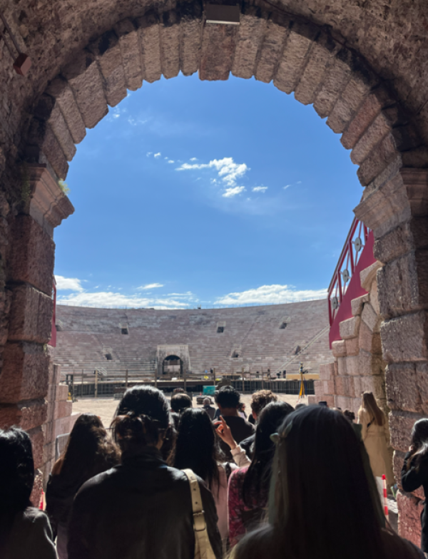 Tourists walking through an entry into Arena di Verona in Verona, Italy.