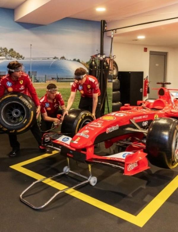 Individuals viewing a race car up close.