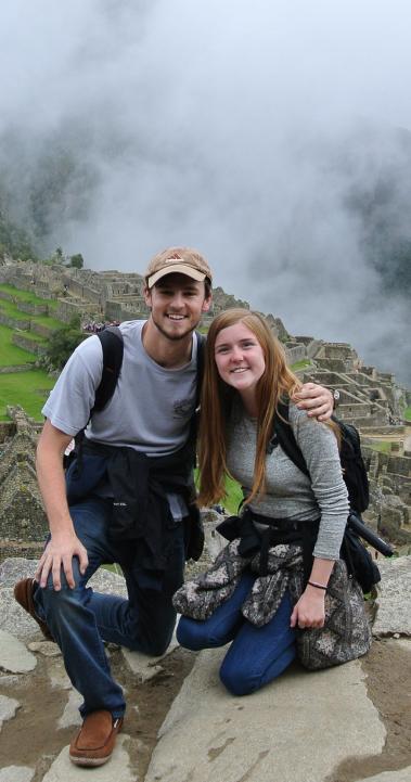 two students pose for the camera in front of machu picchu