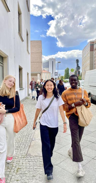 Three students walk on the sidewalk in Berlin, Germany.