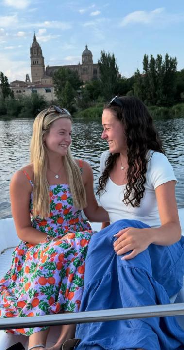 Two female students smile on the rowboats in Salamanca.