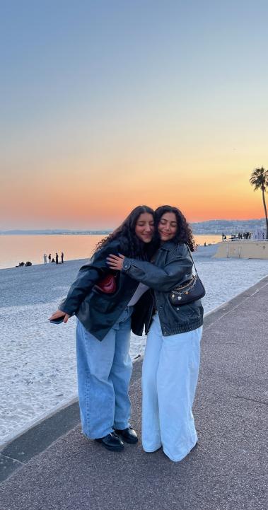 two students hugging on Nice beach at sunset