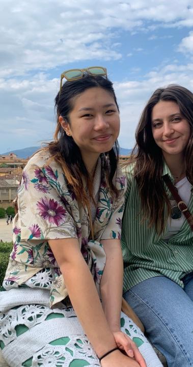 Two friends sitting on a ledge at an overlook of Florence