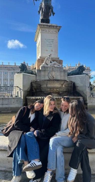Friends soaking up the sun in Plaza de Oriente in Madrid