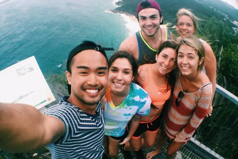 a group of students pose for a photo high up above the ocean in Australia