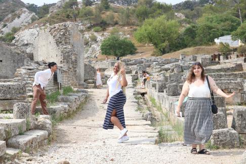 three students pose for a funny photo while visiting Roman ruins in France