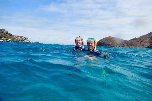 Two students snorkel in the ocean.