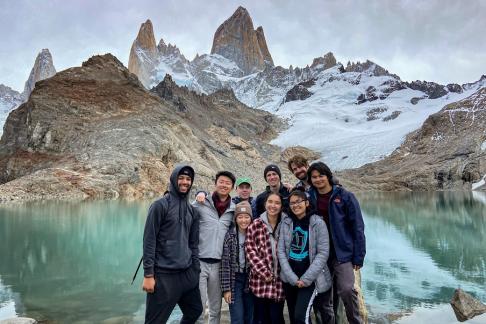 A group of students standing in front of a lake and mountains in Argentina's Patagonia