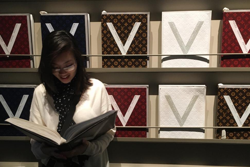 student smiling while reading a book