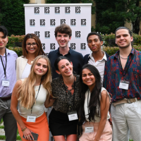 Group of students standing outside in front of an IES Abroad logo backdrop