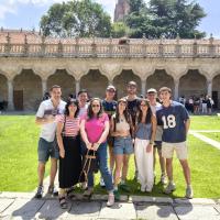 A Group of Students and their teacher in the IES Abroad commons on a sunny day.