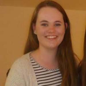 Smiling person in a casual setting, light background. This alt text was added with Al; accuracy may vary.