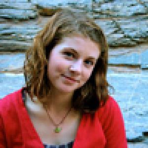 Woman with long brown hair and a neutral expression, outdoors. This alt text was added with Al; accuracy may vary.