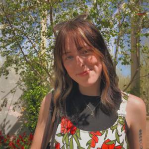 Annika Rader smiling outside in front of a tree.