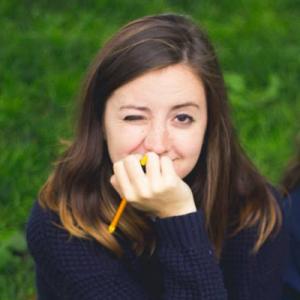 Black and white photo of a person with large glasses, dark hair, and a neutral expression. This alt text was added with Al; accuracy may vary.