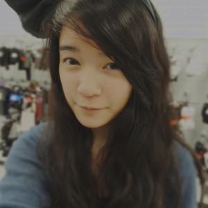 Young woman with long hair, wearing a large black bow. This alt text was added with Al; accuracy may vary.